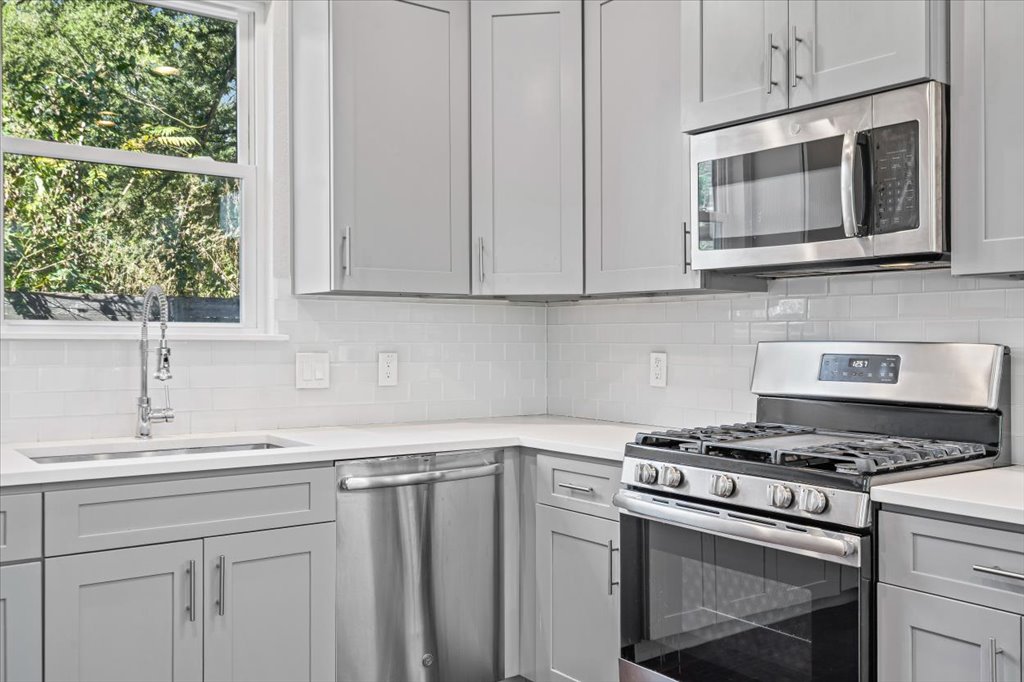 706 Short Kemp Street, Unit 2 Austin, TX 78741 - Photo 13 of 34 a kitchen with stainless steel appliances granite countertop a sink stove and microwave