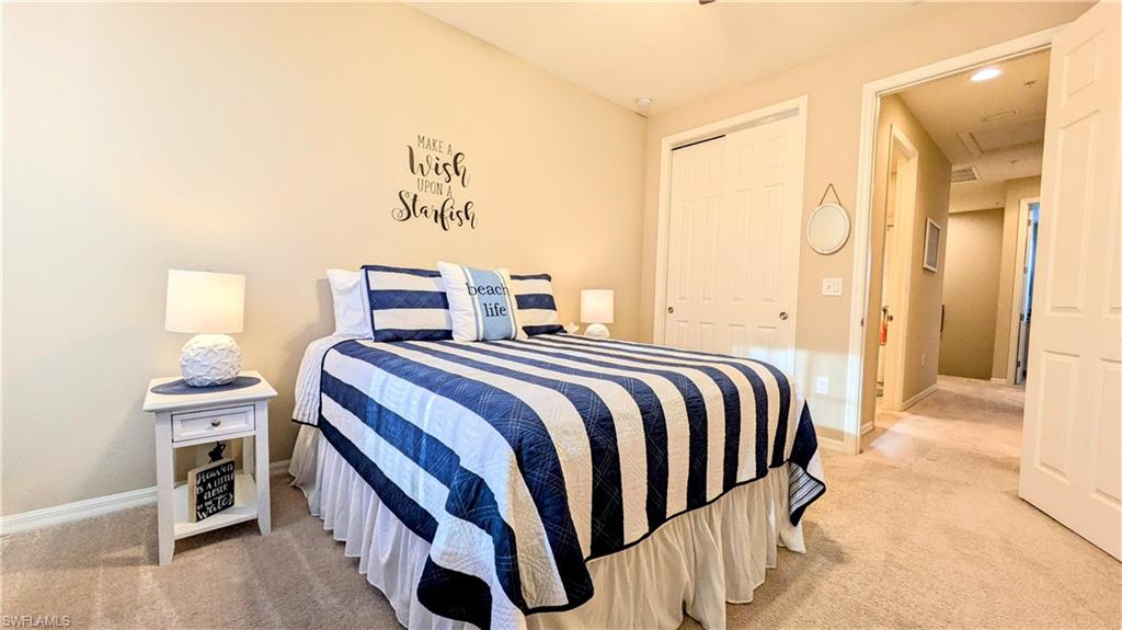 9051 Capistrano Street North, Unit 4308 Naples, FL 34113 - Photo 15 of 45 a bedroom with a bed and a chandelier