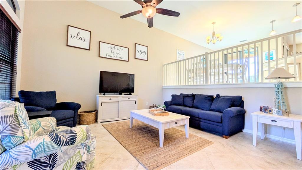 9051 Capistrano Street North, Unit 4308 Naples, FL 34113 - Photo 3 of 45 a living room with furniture and a flat screen tv