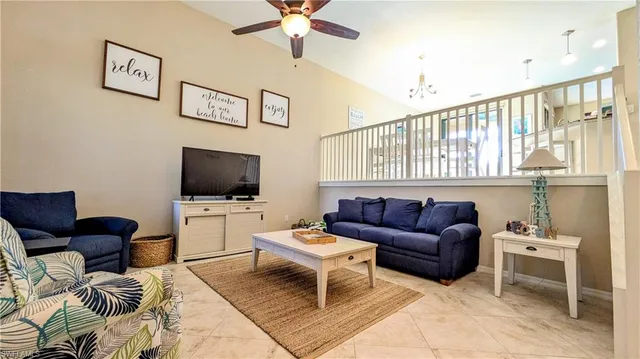 a living room with furniture a flat screen tv and a window