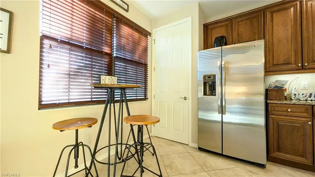 a kitchen with a refrigerator and table chair