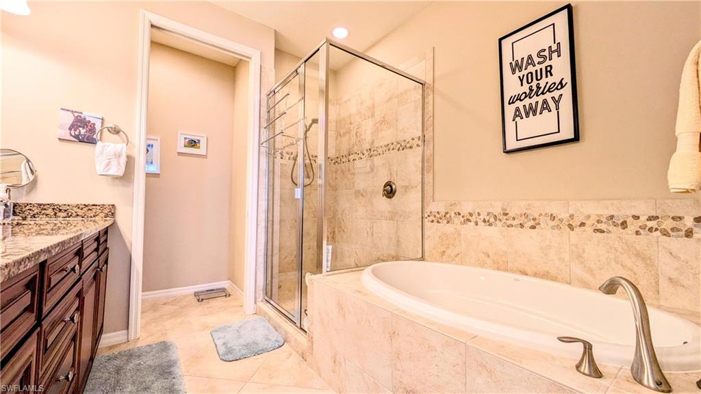 9051 Capistrano Street North, Unit 4308 Naples, FL 34113 - Photo 43 of 45 a spacious bathroom with a tub sink and shower