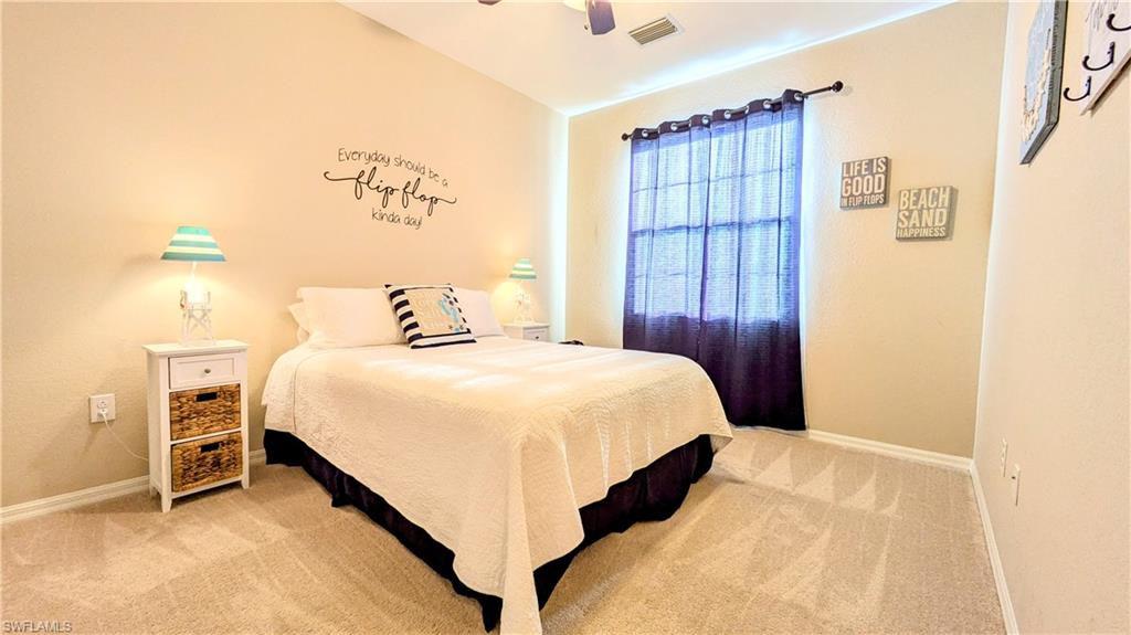 9051 Capistrano Street North, Unit 4308 Naples, FL 34113 - Photo 45 of 45 a bedroom with a bed and a table with wooden floor