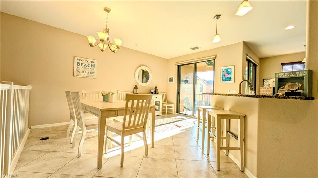 9051 Capistrano Street North, Unit 4308 Naples, FL 34113 - Photo 5 of 45 a view of a dining room with furniture and a chandelier