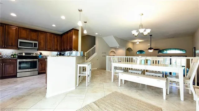 a open kitchen with kitchen island a stove a oven a dining table and chairs