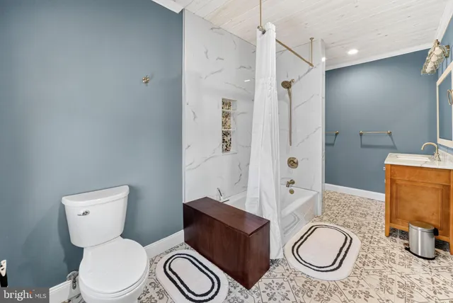 a bathroom with a granite countertop toilet a sink and a mirror