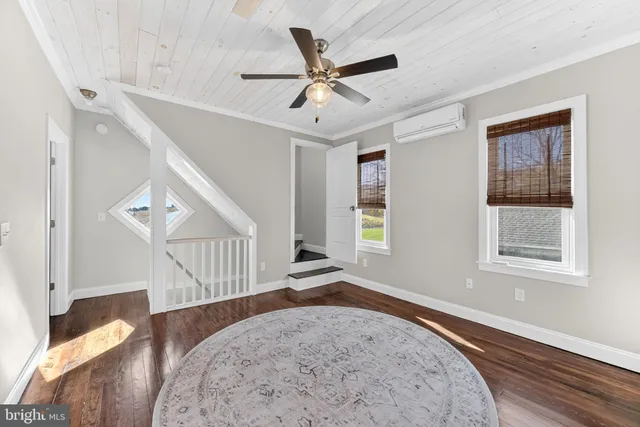 a view of a livingroom with wooden floor and a ceiling fan