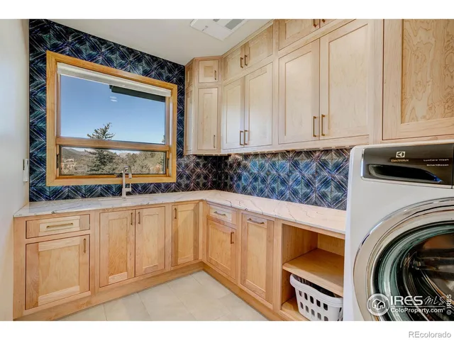 a kitchen with stainless steel appliances granite countertop a stove a sink and white cabinets with wooden floor