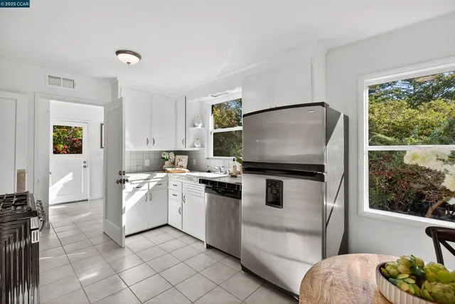 a kitchen with stainless steel appliances granite countertop a refrigerator sink and stove