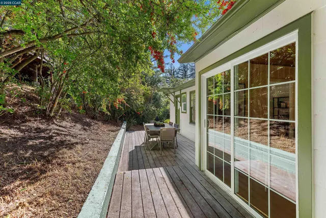 an aerial view of a house with yard and trees in the background