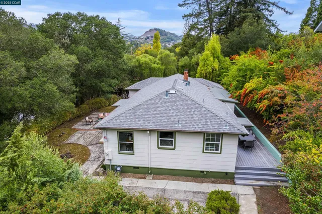a view of house with backyard and a tree