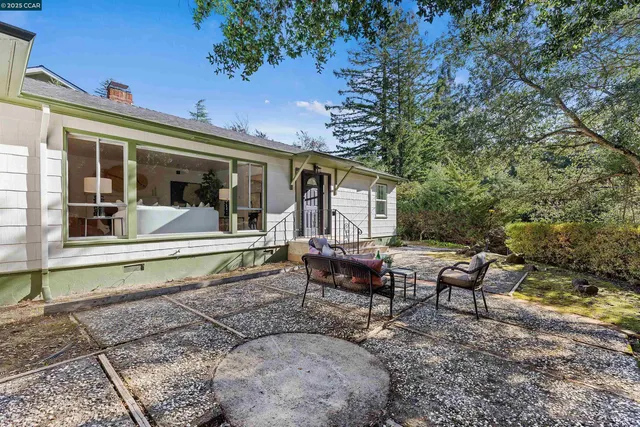 a view of a house with backyard sitting area and garden