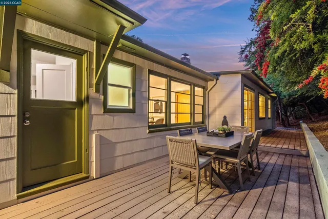 a view of backyard with large tree and wooden fence