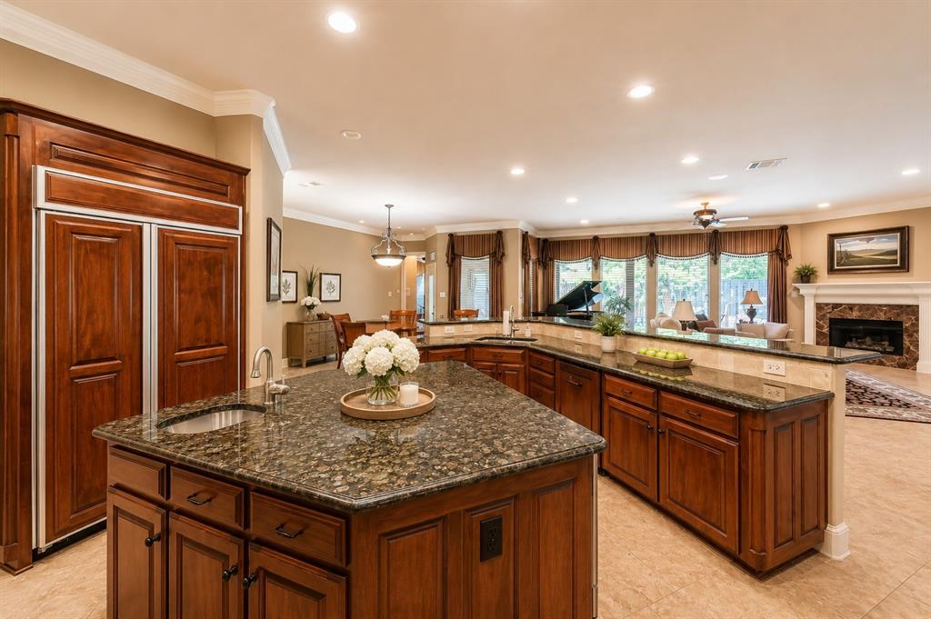 2726 Country Club Road Pantego, TX 76013 - Photo 8 of 23 a kitchen with kitchen island granite countertop wooden cabinets and a refrigerator