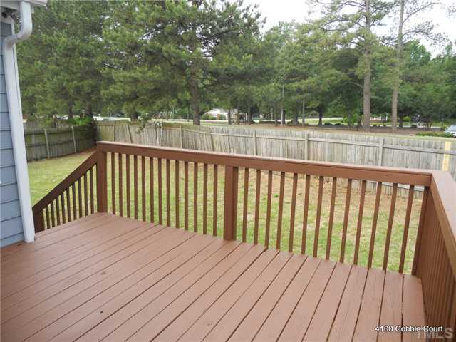 4100 Cobble Court Raleigh, NC 27616 - Photo 11 of 21 a balcony with wooden floor and trees in the back
