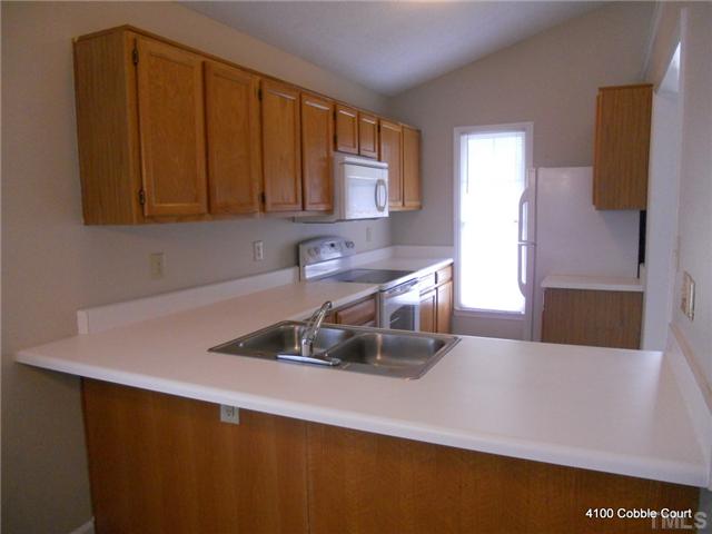 4100 Cobble Court Raleigh, NC 27616 - Photo 5 of 21 a kitchen with a sink and cabinets