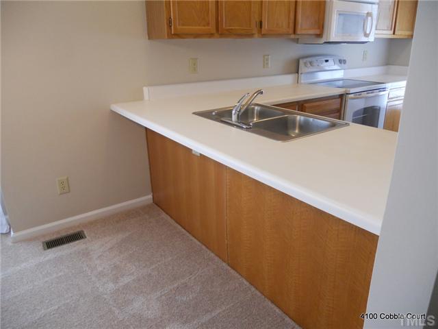 4100 Cobble Court Raleigh, NC 27616 - Photo 7 of 21 a kitchen with a sink and cabinets