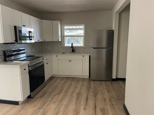 a kitchen with a refrigerator stove and sink