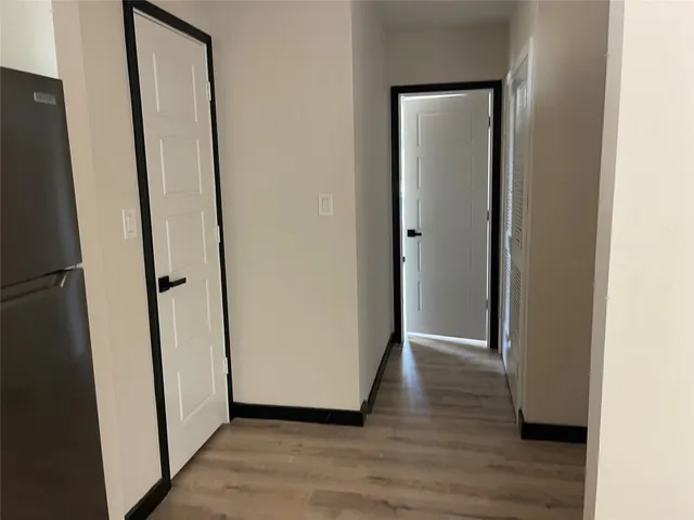 a view of a hallway with wooden floor