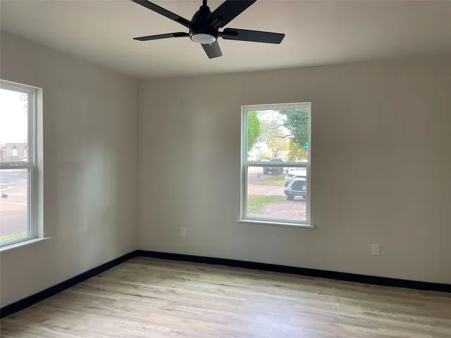 a view of an empty room window and wooden floor