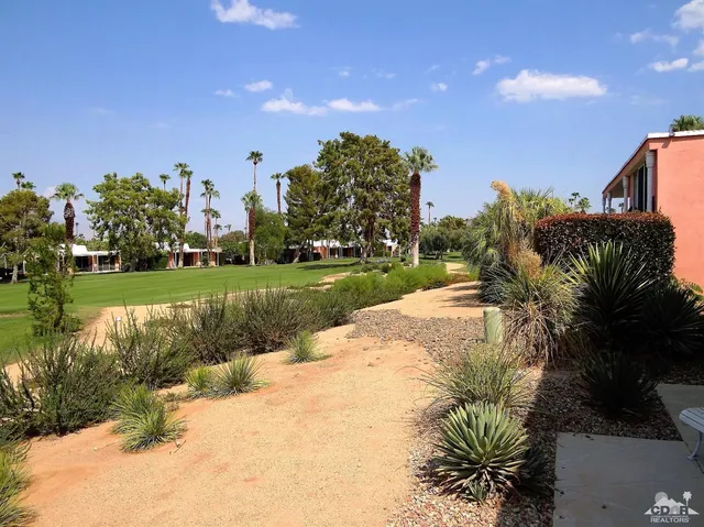 a view of a fountain in front of a house with a big yard