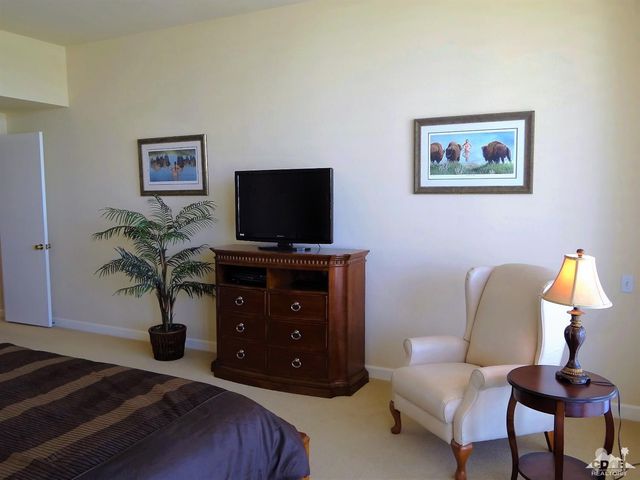 a living room with furniture a flat screen tv and potted plants