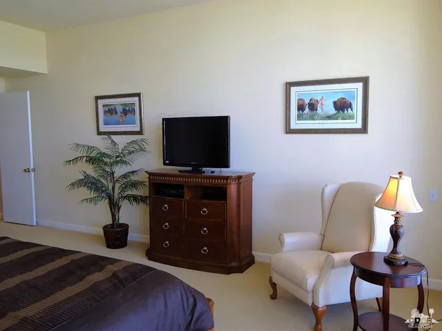a living room with furniture a flat screen tv and potted plants