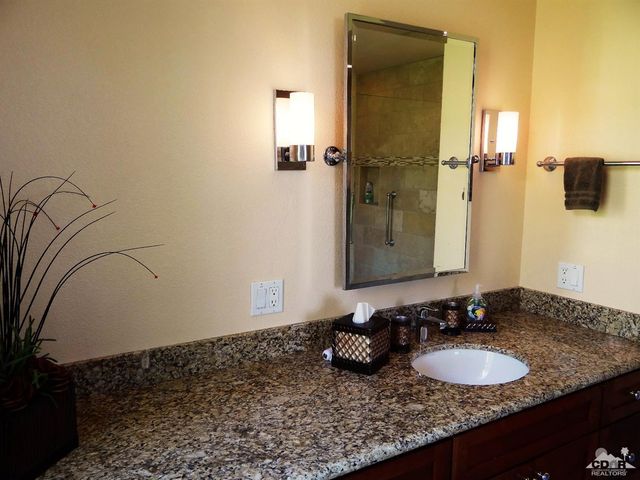 a bathroom with a granite countertop sink and a mirror