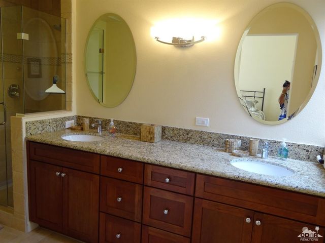a bathroom with a granite countertop double vanity sinks and a mirror
