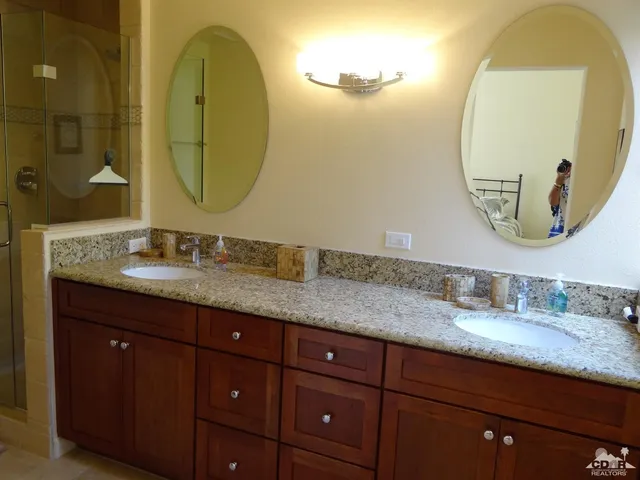 a bathroom with a granite countertop double vanity sinks and a mirror