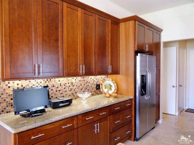 a kitchen with granite countertop wooden cabinets and stainless steel appliances