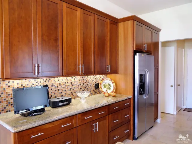 a kitchen with granite countertop wooden cabinets and stainless steel appliances