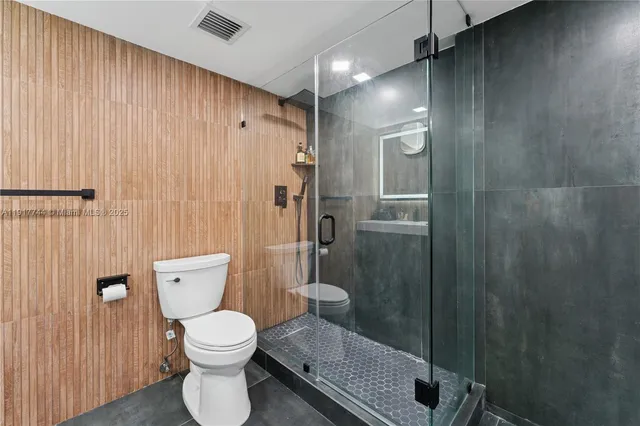 a bathroom with a toilet and a shower