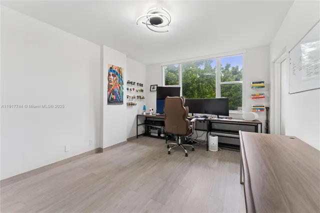 a view of a workspace with furniture and a window