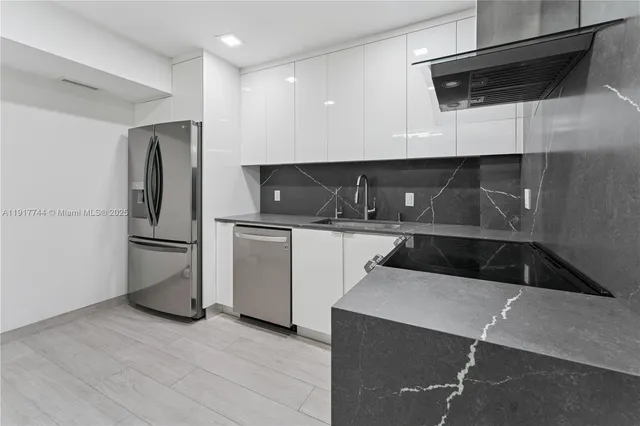 a kitchen with a sink a refrigerator and cabinets