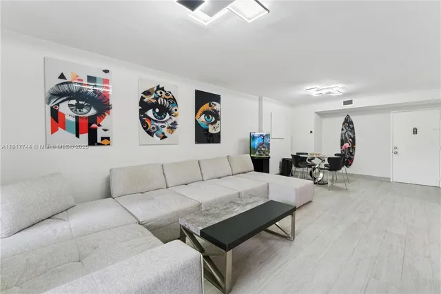 a living room with furniture and a dining table with kitchen view