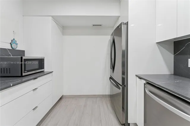 a kitchen with stainless steel appliances granite countertop a refrigerator and a stove