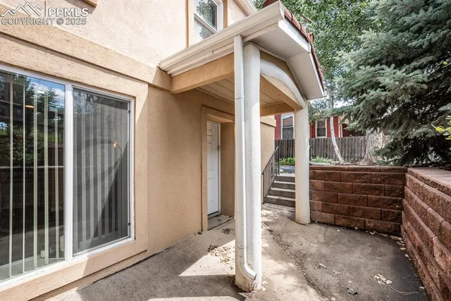 a view of a house with a door and a large tree