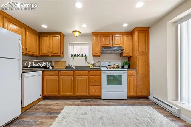 a kitchen with stainless steel appliances granite countertop a stove a sink and a refrigerator