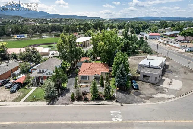 an aerial view of a house with a garden and lake view