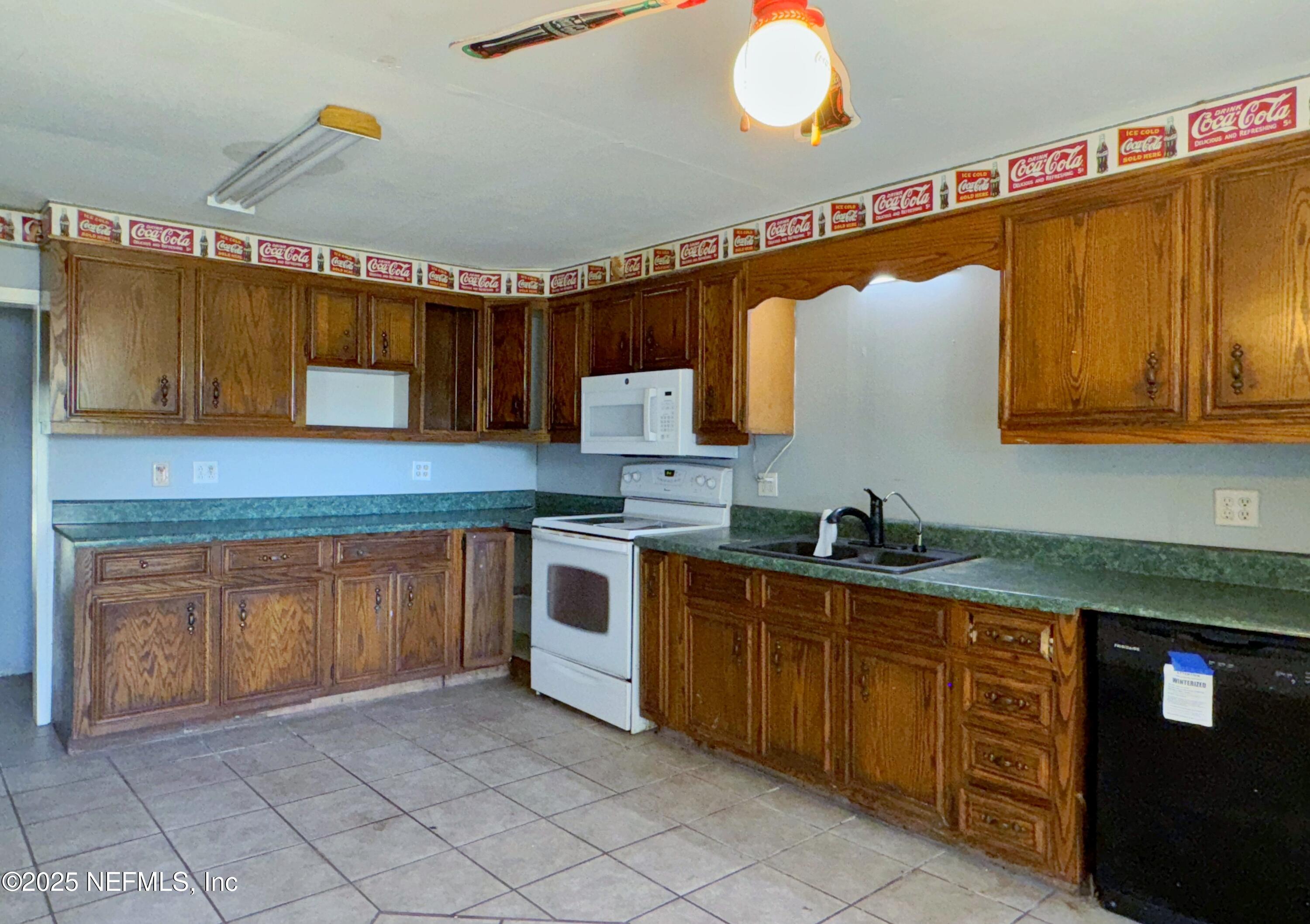 5756 Southeast 55th Terrace Keystone Heights, FL 32656 - Photo 13 of 35 a kitchen with stainless steel appliances granite countertop a sink and cabinets