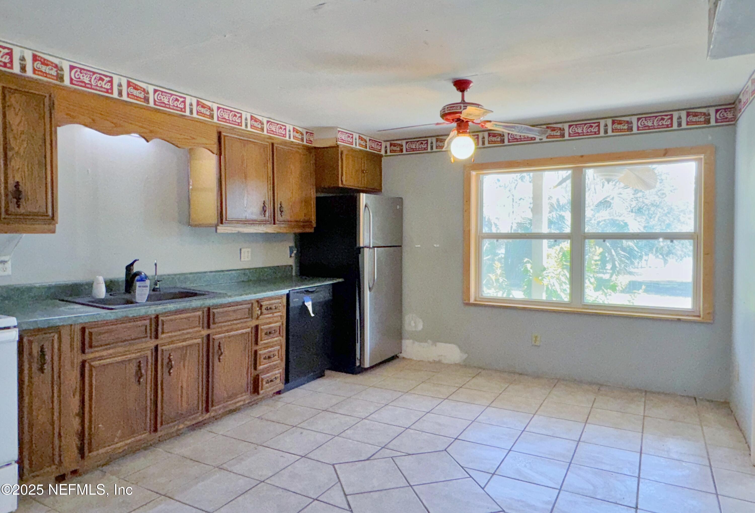 5756 Southeast 55th Terrace Keystone Heights, FL 32656 - Photo 14 of 35 a kitchen with a sink window and refrigerator