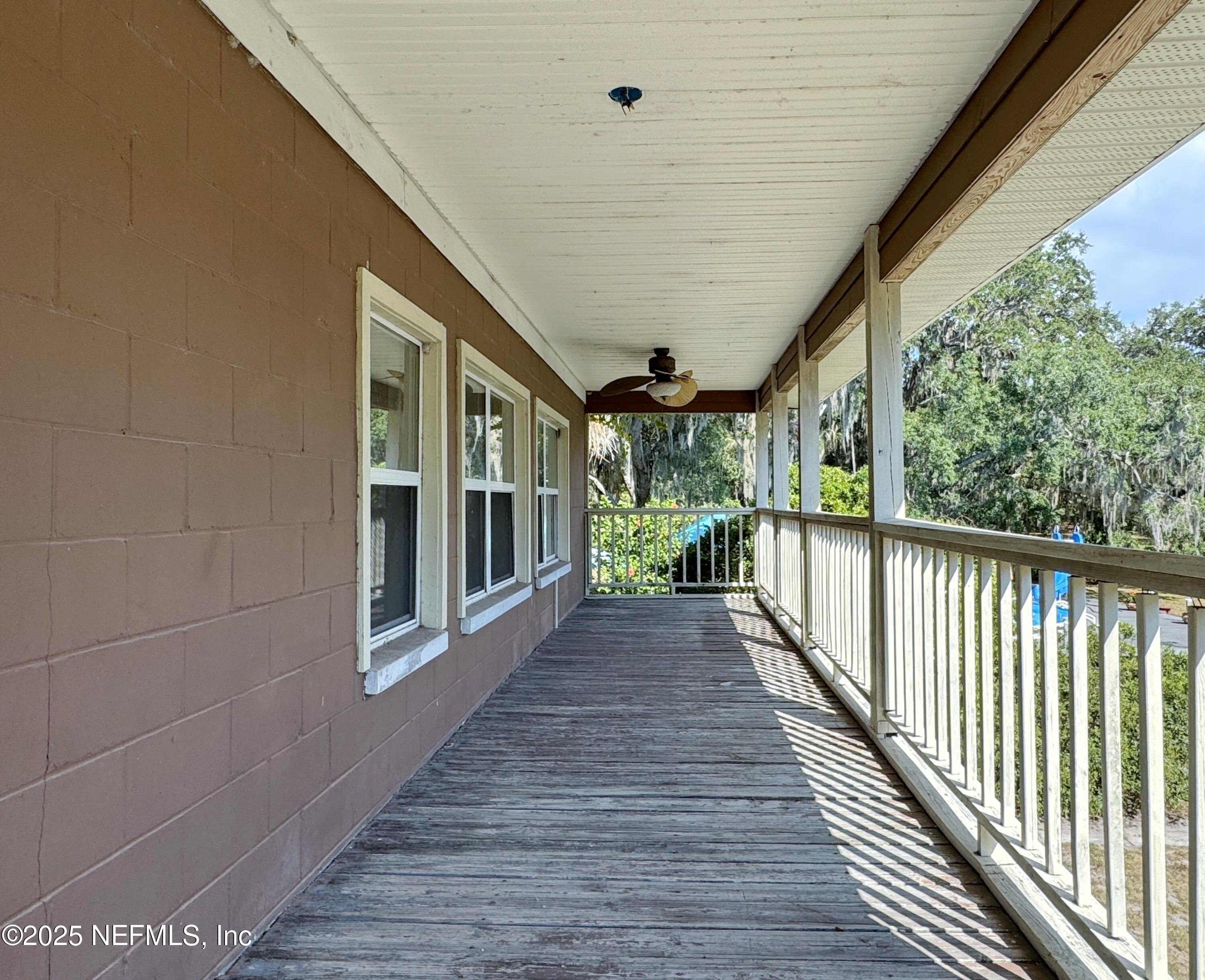 5756 Southeast 55th Terrace Keystone Heights, FL 32656 - Photo 16 of 35 a view of a porch with wooden floor and stairs