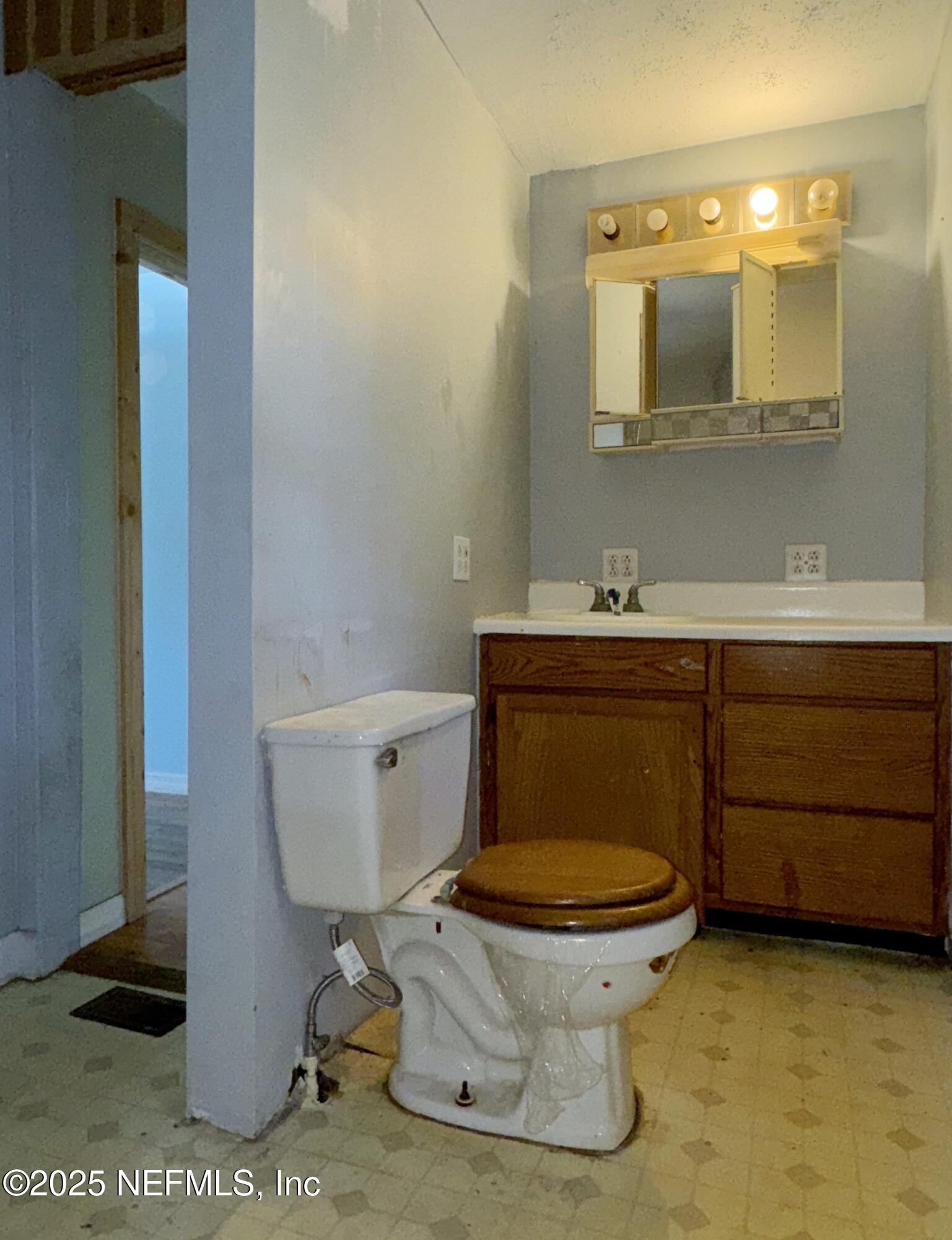 5756 Southeast 55th Terrace Keystone Heights, FL 32656 - Photo 27 of 35 a bathroom with a toilet a sink and mirror