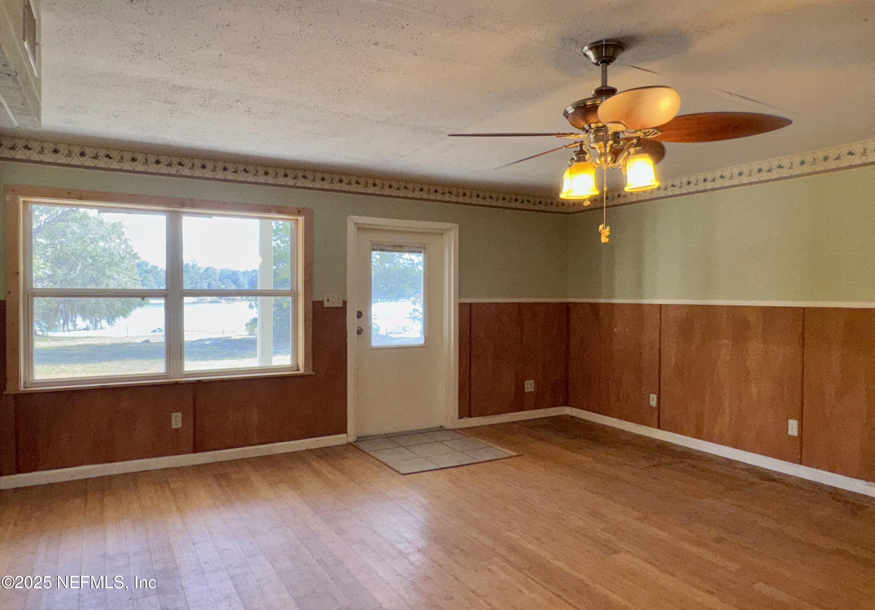 5756 Southeast 55th Terrace Keystone Heights, FL 32656 - Photo 8 of 35 an empty room with wooden floor and windows
