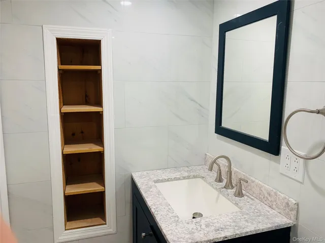 a bathroom with a granite countertop sink and a mirror