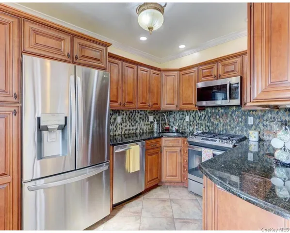 a kitchen with stainless steel appliances granite countertop a refrigerator sink and microwave