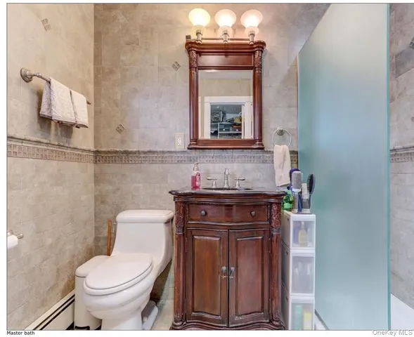 a bathroom with a toilet a sink and mirror