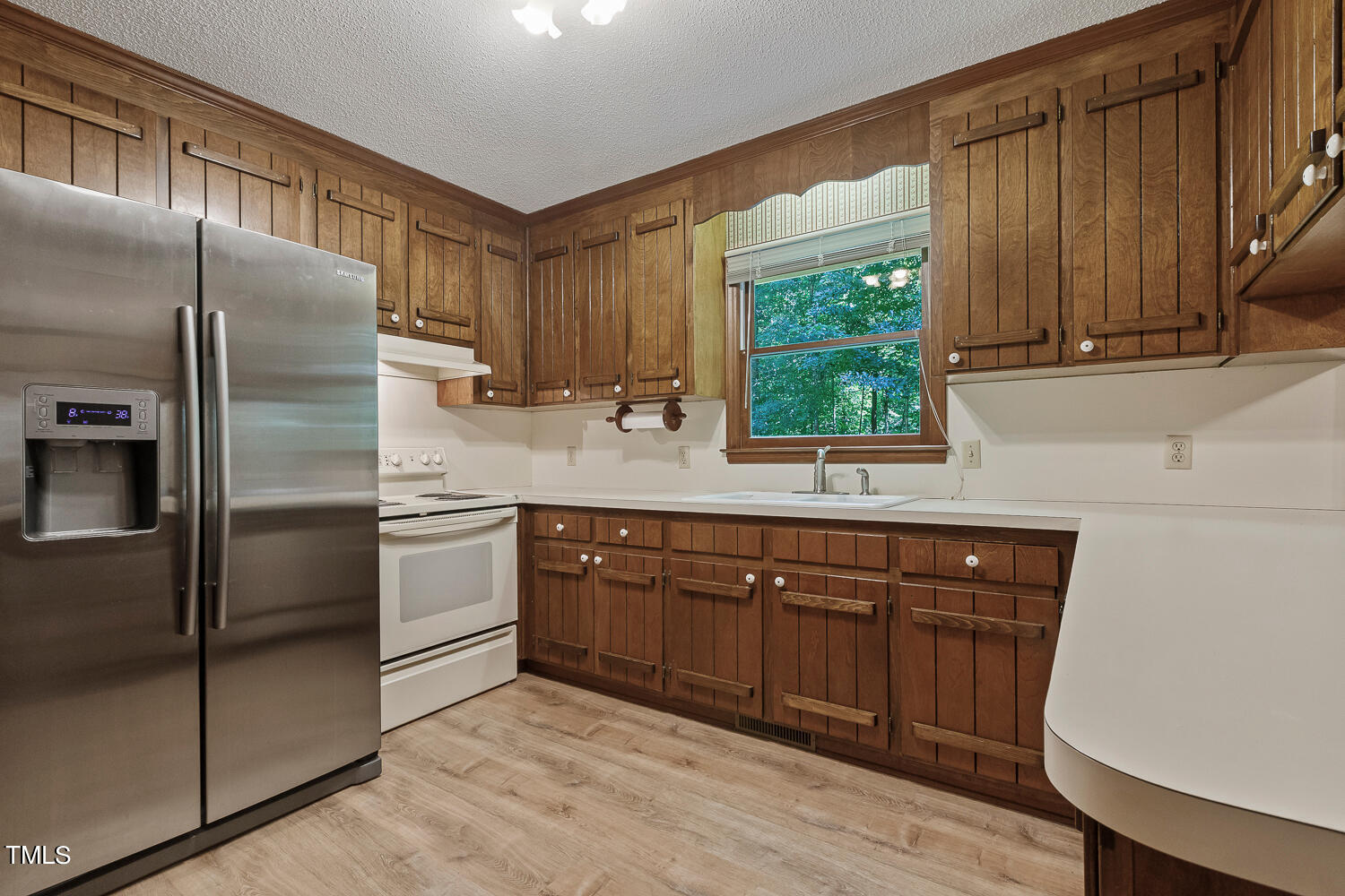 6013 Splitrock Trail Apex, NC 27539 - Photo 14 of 53 a kitchen with stainless steel appliances granite countertop a refrigerator a sink a stove a washer and dryer with wooden floor