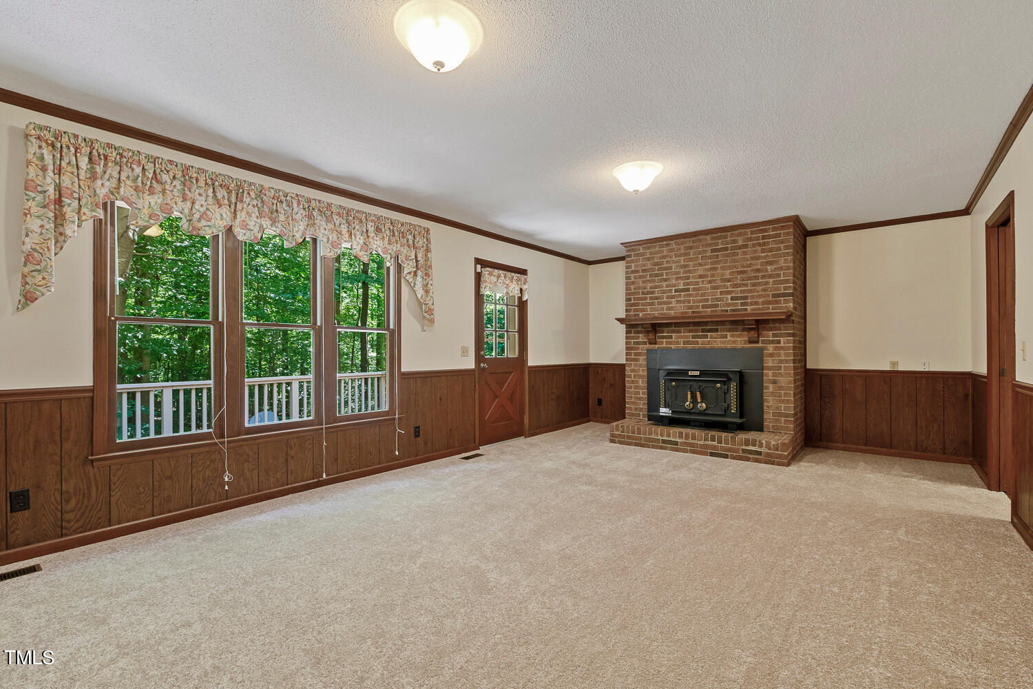 6013 Splitrock Trail Apex, NC 27539 - Photo 24 of 53 a view of an empty room with a fireplace and a window